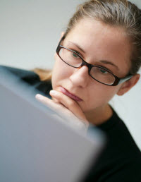 Woman at laptop thinking
