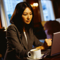 Woman browsing at laptop in cafe