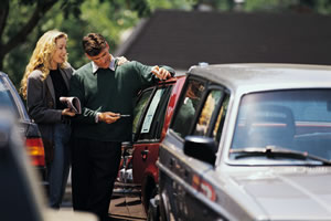 man and woman looking at sticker price of a car
