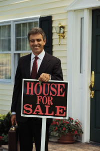 real estate agent with House for Sale sign