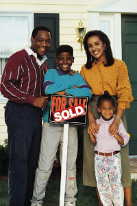 Family in front of house with Sold sign