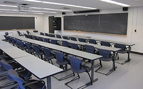 Four rows of tables, with 10 seats in each row. Blackboards at the front of the room.