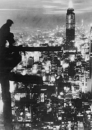 Image of a man sitting high above New York City.