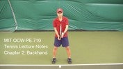 A tennis player stands at the baseline holding the racket in front of him with both hands.