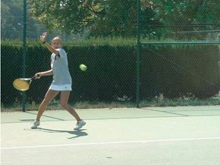 An MIT tennis team member hits a forehand.