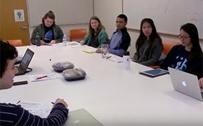 Students sitting around a table in a seminar room.