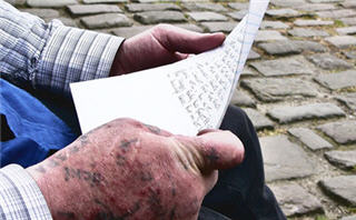 Hands holding a piece of paper.