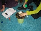 Photo of a student observing a marble roll on the curved mirror surface.