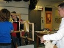 Photo of students looking through the perpendicularly arranged wooden frames at a stuffed dog, a string indicating line-of-sight.