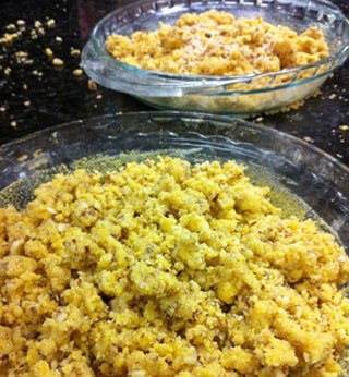 Yellow crumbs sit in two clear glass pie plates.