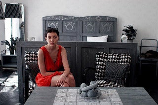 An image of a woman sitting in a black and white room.