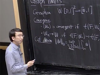 A man standing next to a blackboard.