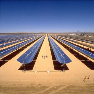 Three people walk between huge mirrored troughs, pointed straight upwards, extending for thousands of feet beyond in all directions. Three people walk between huge mirrored troughs, pointed straight upwards, extending for thousands of feet beyond in all directions.