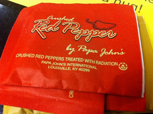 A close-up view of a packet labeled “Crushed red peppers treated with radiation.”