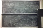 Nuclear energy related equations and graphs on two blackboards.