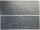 Neutron transport related equations on two blackboards.