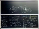 Neutron diffusion related equations and graphs on two blackboards.