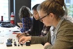 A photo of two girls taking apart a digital camera.