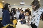 A photo of a group of girls standing around a table.