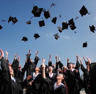 Students throwing graduation caps in the air. 