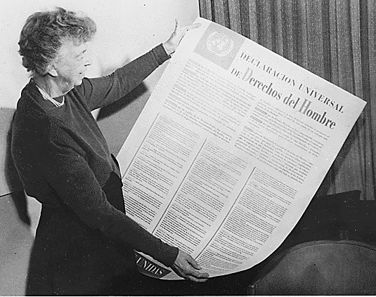 Photo of Eleanor Roosevelt looking at a large copy of the Universal Declaration of Human Rights