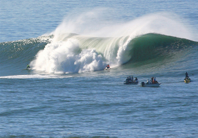 Photo of a large ocean wave with surfers.